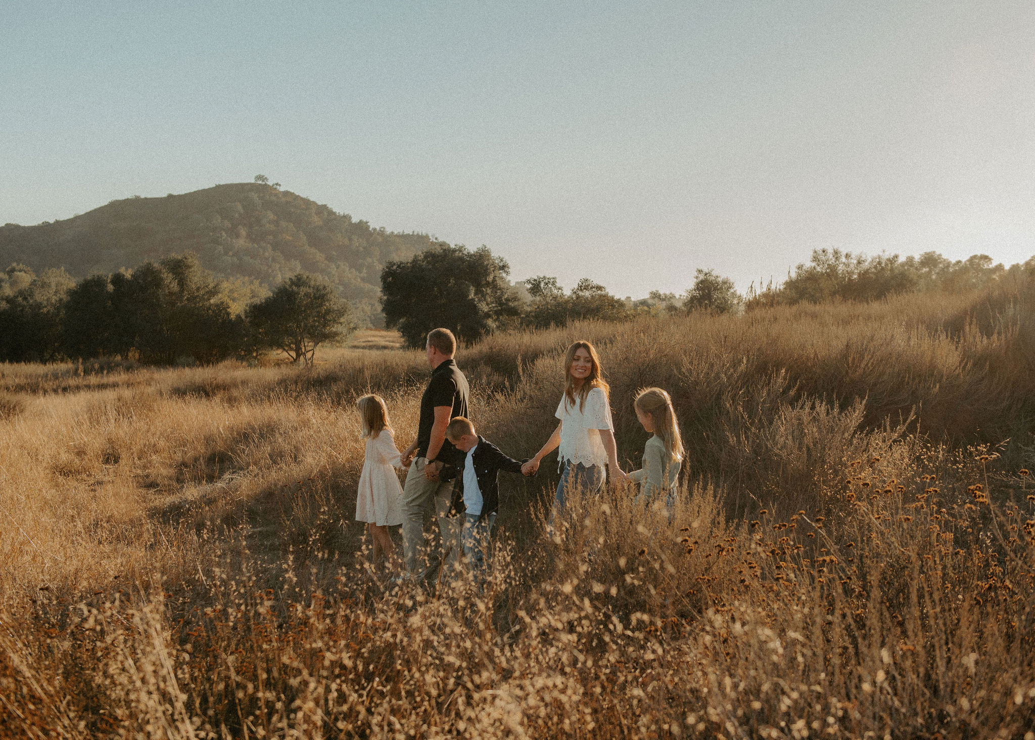 Photographer capturing a family session in golden afternoon light